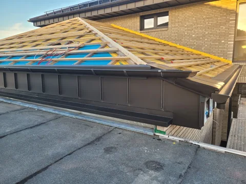 Dachlattung und dunkle Metallverkleidung an einer Dachkante