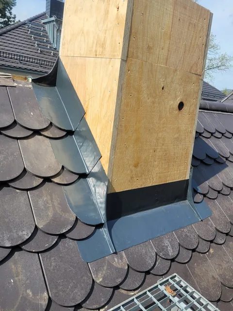 Schornstein mit Holzbekleidung und Blechanschluss am Fuß