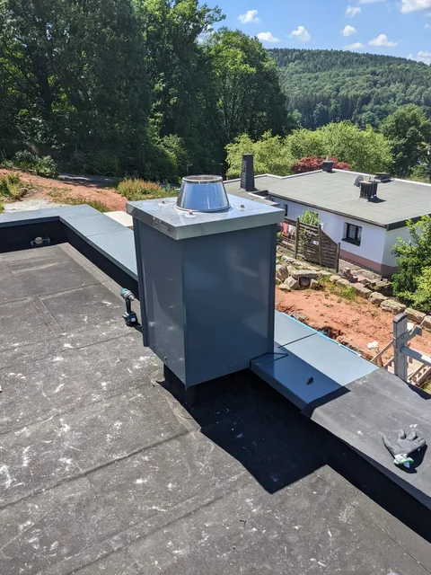 Schornstein mit Metallverkleidung auf einer Dachfläche